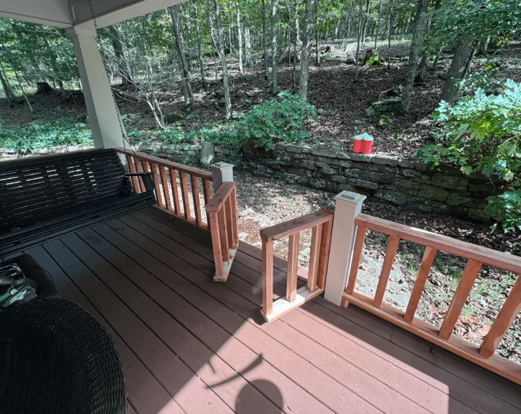 Covered composite deck with cedar railings and porch swing — JHG Contracting LLC serving Lowell, AR